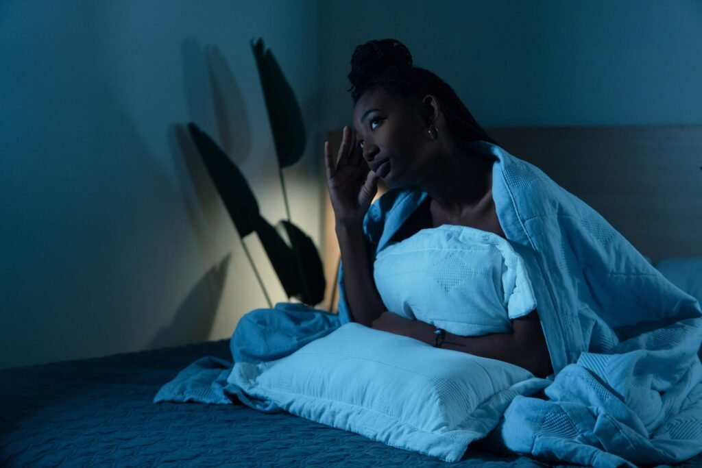 Person suffering from insomnia and anxiety in bed at night using anc for better sleep
